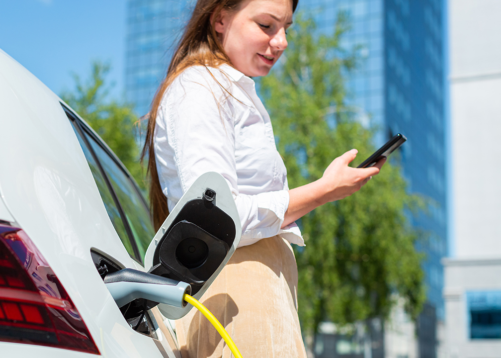 Busy professional charging an electric vehicle